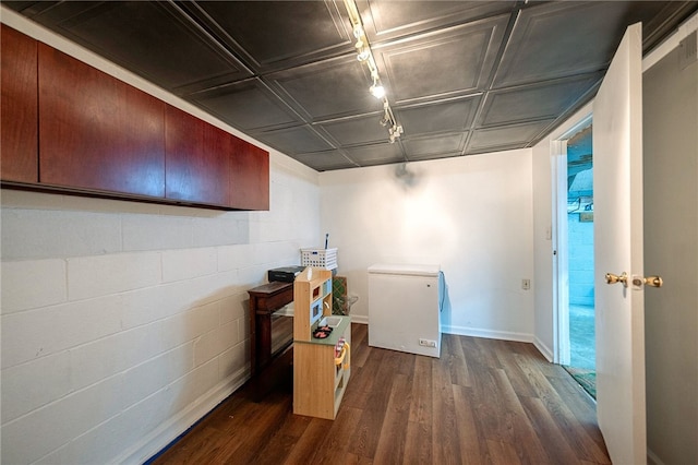 basement featuring fridge and dark hardwood / wood-style floors