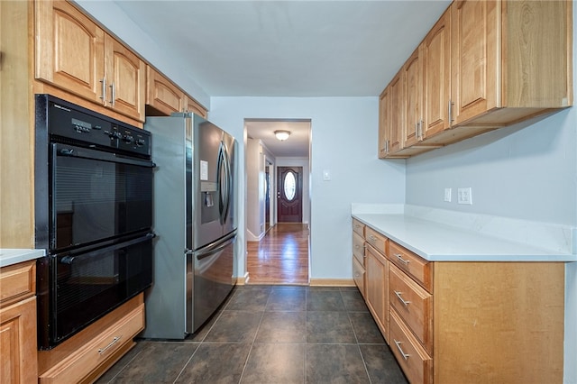 kitchen with black double oven, dark wood-type flooring, and stainless steel fridge