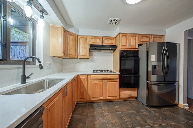 kitchen featuring dark tile patterned flooring, sink, and stainless steel appliances