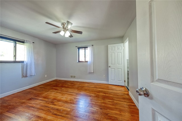 empty room with hardwood / wood-style flooring and ceiling fan