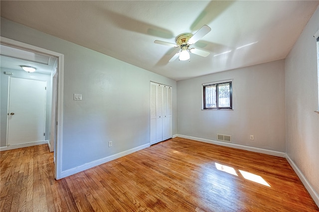 unfurnished bedroom featuring a closet, light hardwood / wood-style floors, and ceiling fan