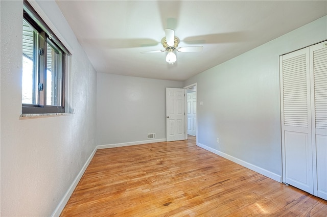 unfurnished bedroom with a closet, light hardwood / wood-style floors, and ceiling fan