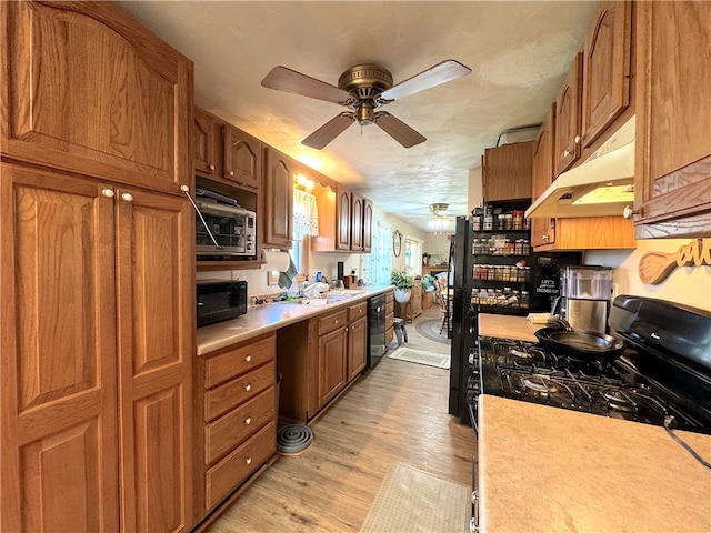 kitchen with black appliances, sink, a textured ceiling, light hardwood / wood-style floors, and ceiling fan