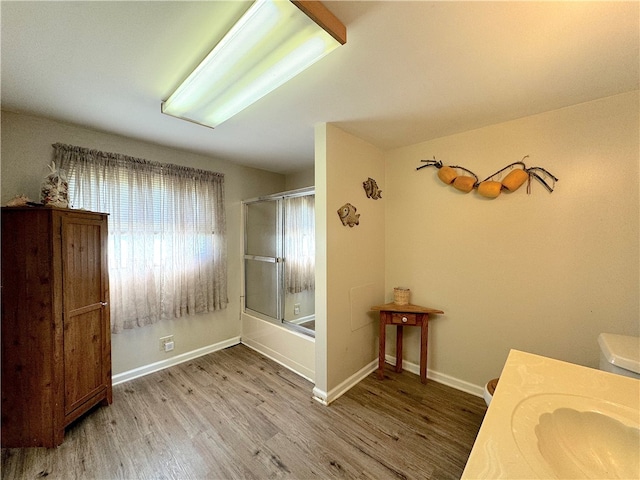 bathroom with vanity, combined bath / shower with glass door, and hardwood / wood-style flooring