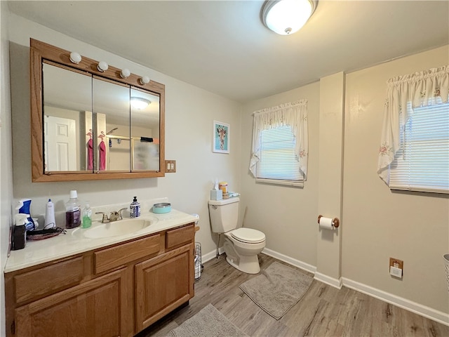 bathroom with vanity, toilet, and hardwood / wood-style floors