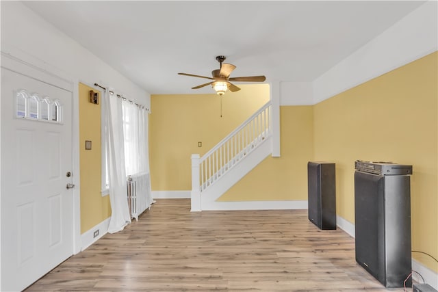 entryway with radiator, ceiling fan, and light wood-type flooring