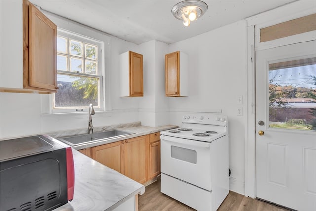 kitchen with light hardwood / wood-style floors, light brown cabinets, white electric range, and sink