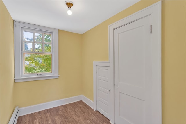 empty room featuring baseboard heating and light wood-type flooring