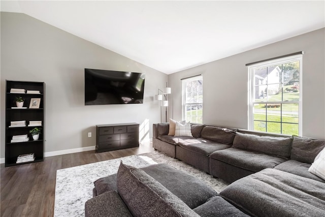 living room with a wealth of natural light, dark wood-type flooring, and vaulted ceiling