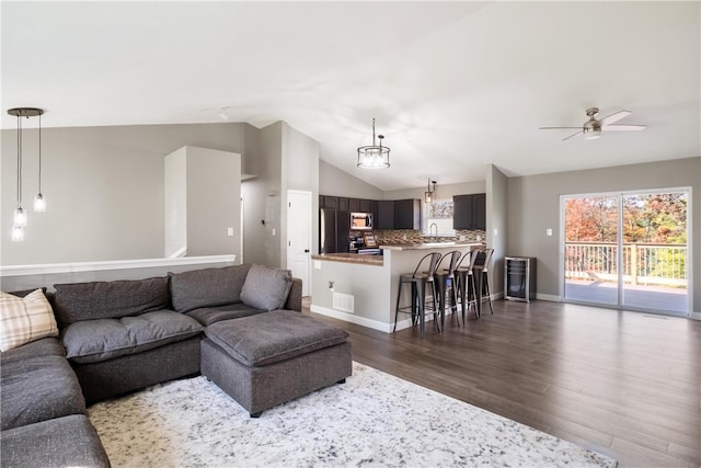 living room with vaulted ceiling, dark hardwood / wood-style flooring, and ceiling fan