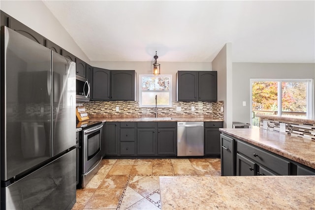 kitchen featuring vaulted ceiling, stainless steel appliances, decorative backsplash, and sink