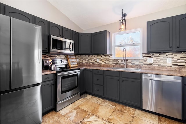 kitchen featuring appliances with stainless steel finishes, sink, hanging light fixtures, vaulted ceiling, and decorative backsplash