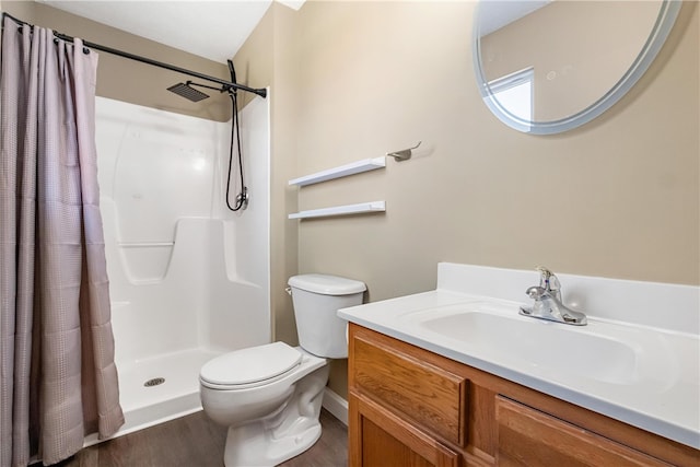 bathroom with toilet, hardwood / wood-style floors, walk in shower, and vanity