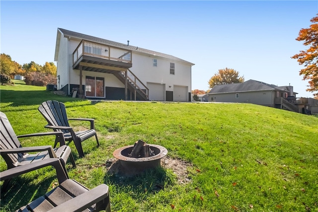 back of house featuring a yard and an outdoor fire pit