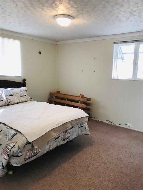 carpeted bedroom featuring a textured ceiling