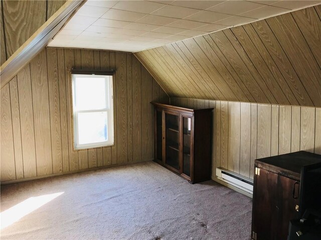 bonus room with wood walls, a baseboard heating unit, and light colored carpet