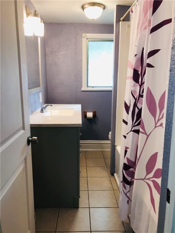 bathroom featuring vanity, a shower with curtain, toilet, and tile patterned floors