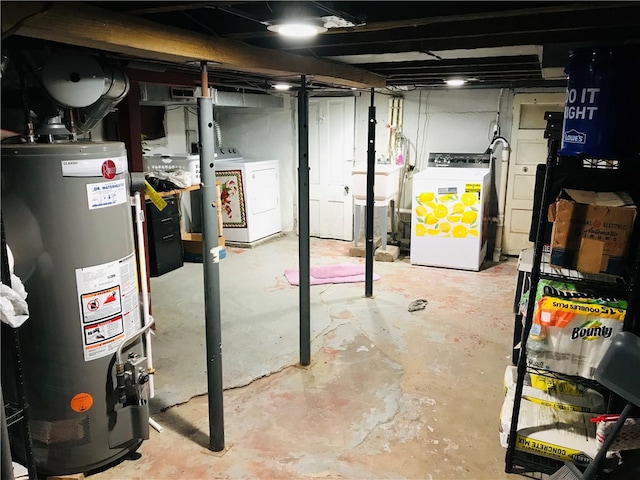 basement featuring sink, water heater, and separate washer and dryer