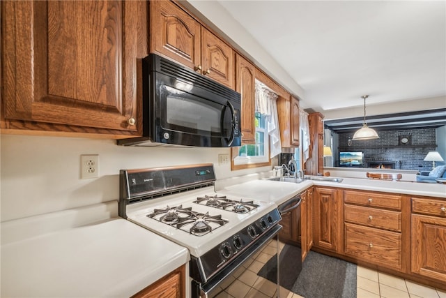 kitchen featuring dishwasher, white gas stove, sink, decorative light fixtures, and light tile patterned floors