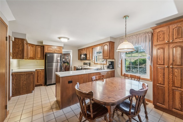 kitchen featuring sink, appliances with stainless steel finishes, pendant lighting, and light tile patterned floors