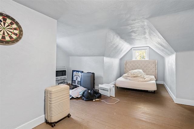 bonus room featuring lofted ceiling, hardwood / wood-style flooring, and heating unit