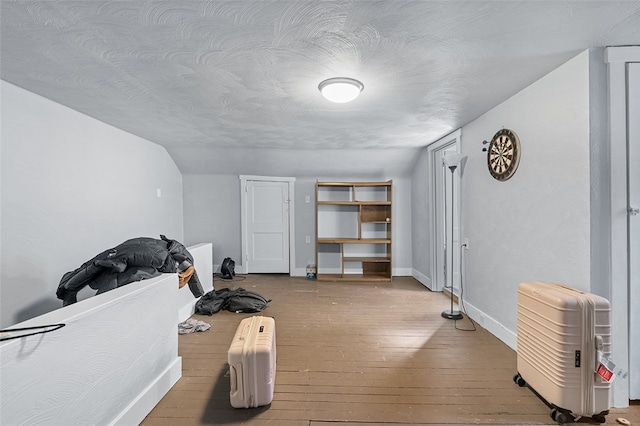 interior space with light hardwood / wood-style floors, lofted ceiling, and a textured ceiling