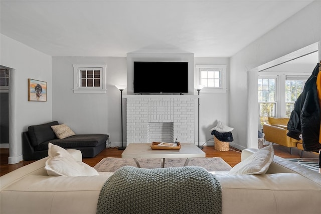 living room with a brick fireplace and light hardwood / wood-style floors