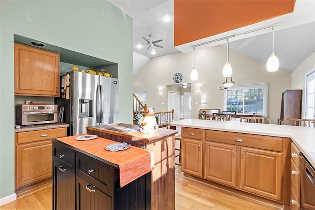 kitchen featuring light hardwood / wood-style flooring, a center island, decorative light fixtures, and stainless steel appliances