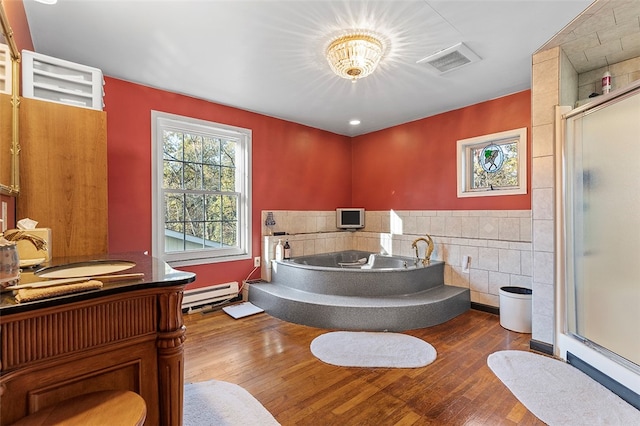 bathroom featuring hardwood / wood-style flooring, tile walls, shower with separate bathtub, and baseboard heating