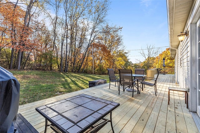 deck featuring a grill and a lawn