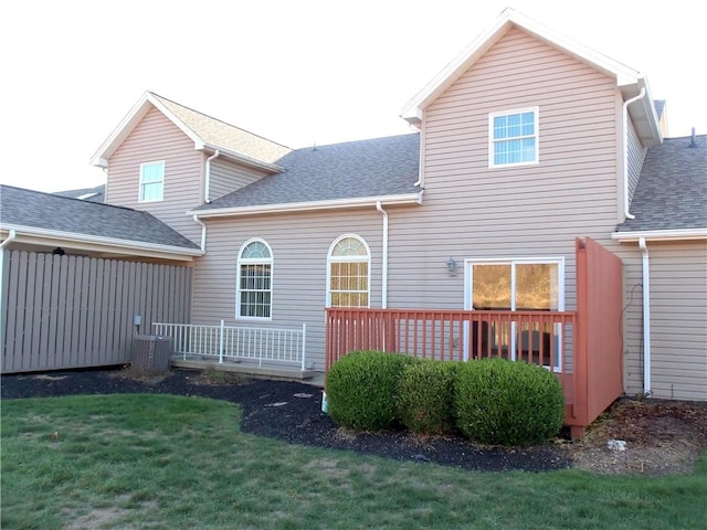 rear view of house featuring a lawn and central air condition unit