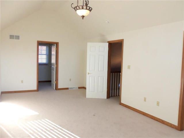 carpeted spare room with lofted ceiling