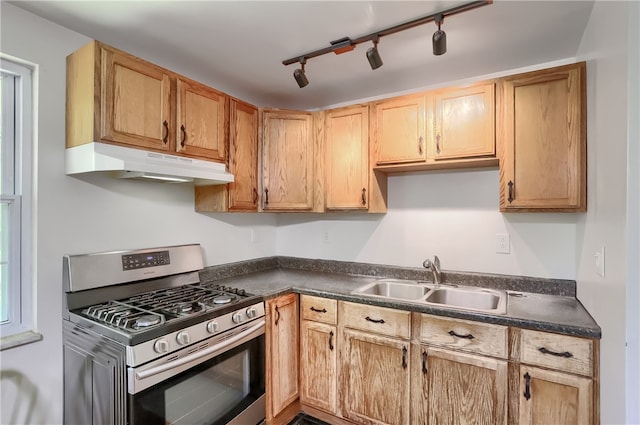 kitchen with rail lighting, gas stove, and sink