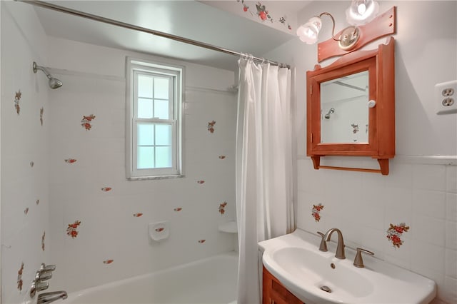 bathroom with vanity, tile walls, and shower / bath combo