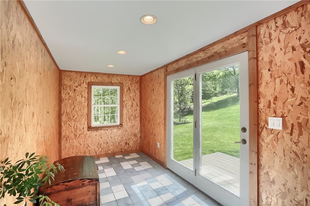 doorway to outside featuring ornamental molding and light tile patterned floors