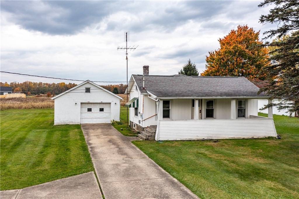 view of front of house featuring a front lawn, an outbuilding, and a garage