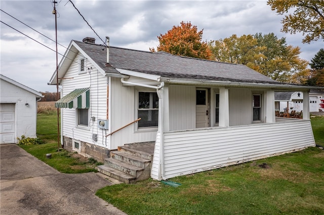 view of front of home featuring covered porch, a front lawn, and a garage