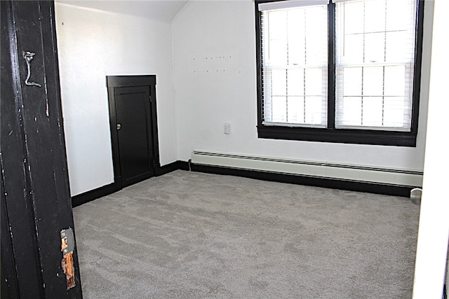 carpeted spare room with lofted ceiling and a baseboard radiator