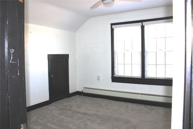 carpeted empty room featuring lofted ceiling, baseboard heating, and ceiling fan