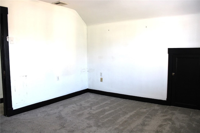 carpeted spare room featuring lofted ceiling