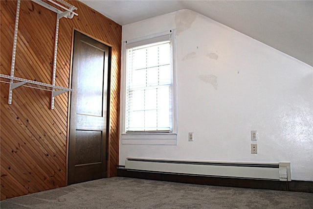 interior space with baseboard heating, lofted ceiling, and wood walls