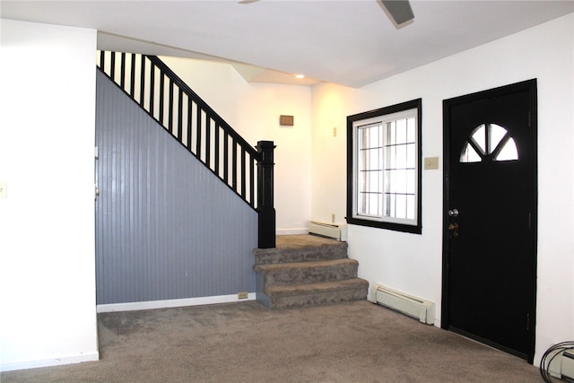 foyer entrance with baseboard heating and dark colored carpet