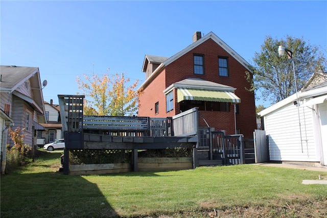 back of property featuring a yard and a deck