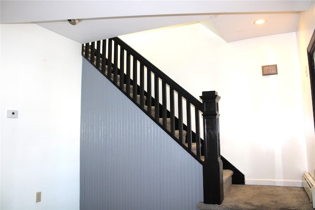 staircase featuring carpet and a baseboard heating unit