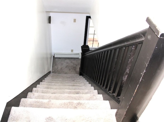 stairway featuring a baseboard heating unit and carpet flooring