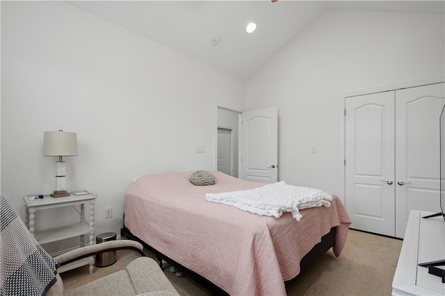 carpeted bedroom featuring a closet and high vaulted ceiling