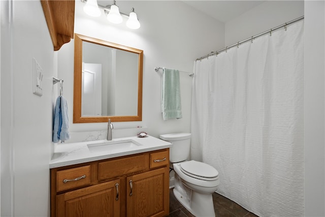 bathroom with toilet, vanity, and tile patterned flooring