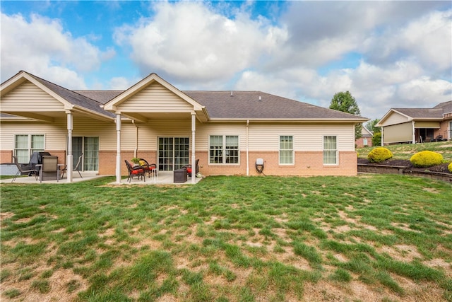 rear view of house with a patio area and a lawn