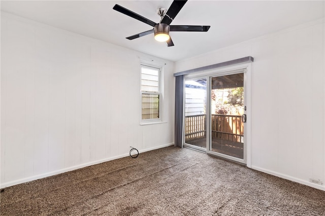 empty room featuring a wealth of natural light, carpet, and ceiling fan