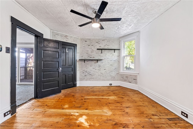 empty room featuring ornamental molding, hardwood / wood-style floors, and ceiling fan